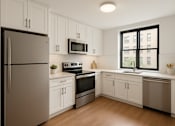 Thumbnail 10 of 14 - A kitchen with white cabinets and a black fridge.