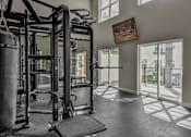 Thumbnail 1 of 5 - a home gym with weights and a doorway to a balcony