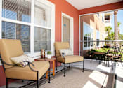 Thumbnail 9 of 17 - a porch with two chairs and a table and windows