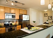 Thumbnail 8 of 17 - a kitchen with granite counter tops and stainless steel appliances