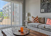 Thumbnail 4 of 16 - a living room with a couch and a sliding glass door to a patio