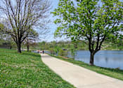 Thumbnail 4 of 11 - people walking along a path next to a lake