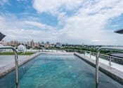 Thumbnail 3 of 6 - a swimming pool on the roof of a building with a city in the background