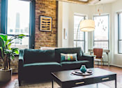 Thumbnail 4 of 6 - a living room with a green couch and a coffee table
