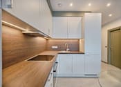 Thumbnail 6 of 6 - a modern kitchen with white cabinets and a wooden counter top