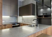 Thumbnail 1 of 5 - A modern kitchen with a stainless steel sink and wooden cabinets.