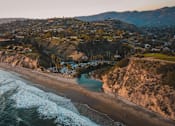 Thumbnail 3 of 6 - arial view of a beach with houses on the cliffs