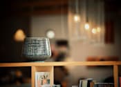 Thumbnail 3 of 8 - A small speaker is on a shelf with books.