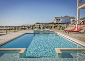 Thumbnail 3 of 8 - A swimming pool with a wooden deck and a red bench.