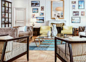 Thumbnail 1 of 8 - A living room with a fireplace and a couch.