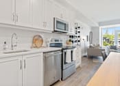 Thumbnail 4 of 12 - a kitchen with white cabinets and stainless steel appliances
