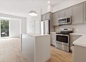Thumbnail 3 of 12 - a kitchen with gray cabinets and a white island