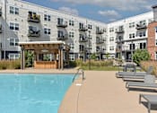Thumbnail 11 of 16 - a swimming pool in front of an apartment building
