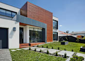 Thumbnail 1 of 6 - a modern house with a lawn and a grassy yard