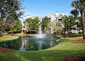 Thumbnail 7 of 17 - a fountain in the middle of a pond in front of a building