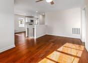 Thumbnail 10 of 11 - A room with a wooden floor and a ceiling fan.