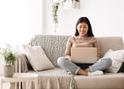 Thumbnail 8 of 8 - a woman sitting on a couch with a laptop