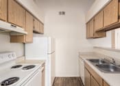 Thumbnail 18 of 21 - A kitchen with white appliances and wooden cabinets.