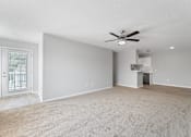 Thumbnail 21 of 34 - an empty living room with a ceiling fan and a kitchen
