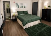 Thumbnail 6 of 10 - A bedroom with a bed, nightstand, and chair.