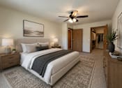Thumbnail 6 of 38 - A bedroom with a large bed, a ceiling fan, and a painting on the wall.