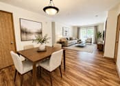 Thumbnail 1 of 38 - A dining room with a wooden table and chairs.
