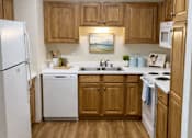 Thumbnail 3 of 38 - A kitchen with wooden cabinets and white appliances.