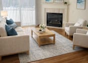Thumbnail 9 of 38 - A living room with a fireplace and a couch.