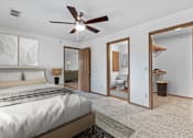 Thumbnail 7 of 12 - A bedroom with a large bed and a ceiling fan.