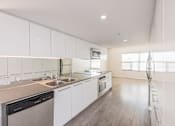 Thumbnail 38 of 47 - A modern kitchen with white cabinets and stainless steel appliances.