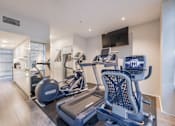 Thumbnail 29 of 47 - A modern home gym with a treadmill and a stationary bike.