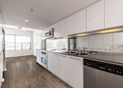 Thumbnail 34 of 47 - A modern kitchen with white cabinets and stainless steel appliances.