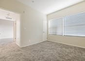 Thumbnail 31 of 47 - A room with a carpeted floor and a window with blinds.
