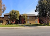 Thumbnail 20 of 38 - Street view of well kept landscapting at Riverdale Apartment Homes in Hemet, California.
