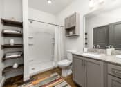 Thumbnail 7 of 18 - a bathroom with gray cabinets and white walls