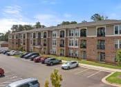 Thumbnail 18 of 18 - a large apartment complex with a parking lot in front of it