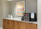 Thumbnail 17 of 40 - a kitchen counter with a coffee maker and a painting on the wall