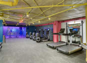 Thumbnail 23 of 40 - a gym with cardio equipment and a colorful wall in a building