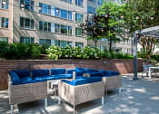 Thumbnail 33 of 40 - a patio with blue couches and chairs in front of a building