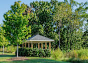 Thumbnail 17 of 33 - A gazebo is surrounded by greenery and trees.