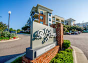 Thumbnail 9 of 33 - The sign for The Green apartments is in front of a street.