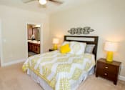 Thumbnail 25 of 33 - A bedroom with a bed, nightstand, and a ceiling fan.