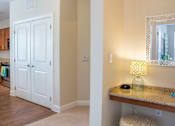 Thumbnail 23 of 33 - A kitchen with a white door and a counter with a lamp on it.