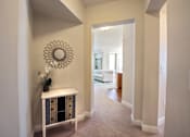 Thumbnail 24 of 33 - A hallway with a white console table and a mirror on the wall.