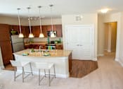Thumbnail 4 of 33 - A kitchen with a white island and bar stools.