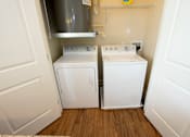 Thumbnail 27 of 33 - A small laundry room with a washer and dryer.