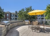 Thumbnail 16 of 26 - exterior clubhouse outdoor kitchen located by pool with seating