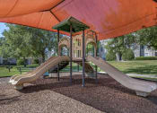 Thumbnail 25 of 26 - exterior playground with two slides and a climbing structure