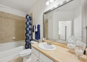 Thumbnail 7 of 26 - a bathroom with a sink and a tub and a mirror