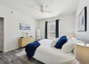 Thumbnail 6 of 26 - a bedroom with a large bed and a ceiling fan